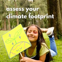 A girl lies on her stomach in a forest, she's holding a hand drawn sign of the earth. Text reads: assess your climate footprint. 